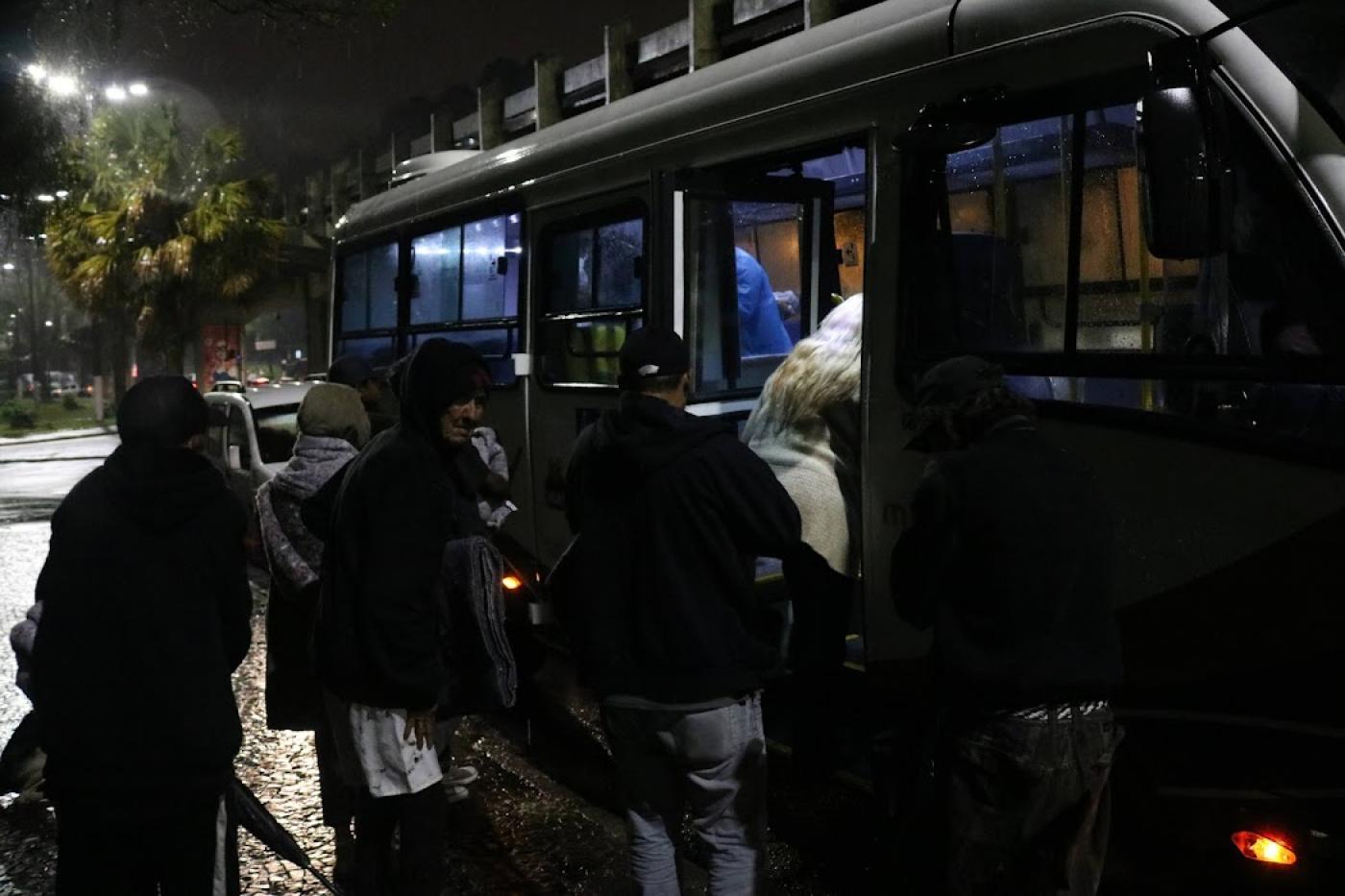 pessoas em situação de rua subindo em ônibus #paratodosverem