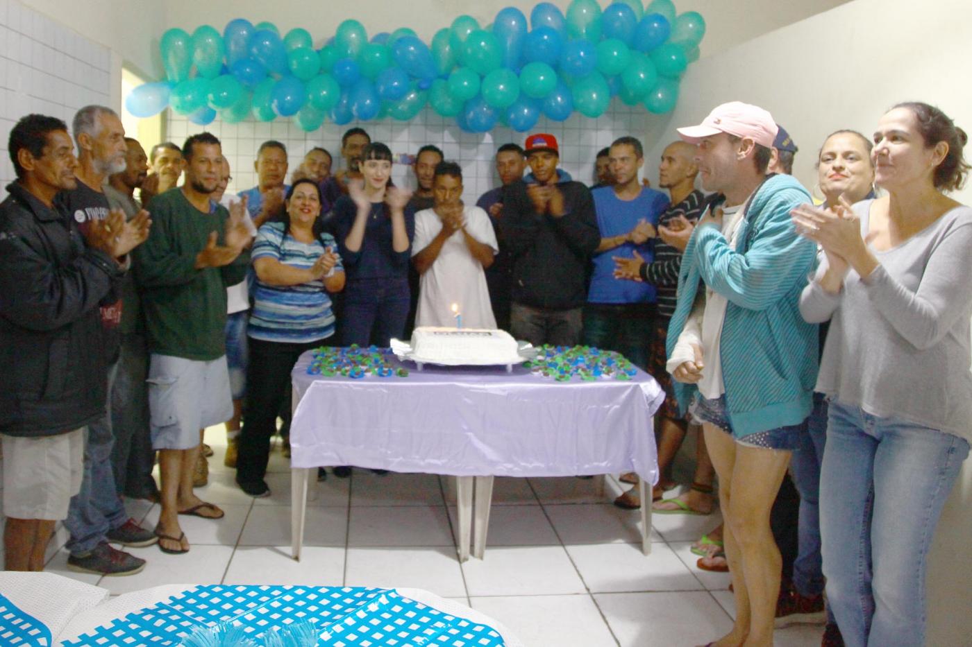 servidores e pessoas em situação de rua cantam parabéns ao redor de bolo #pracegover 