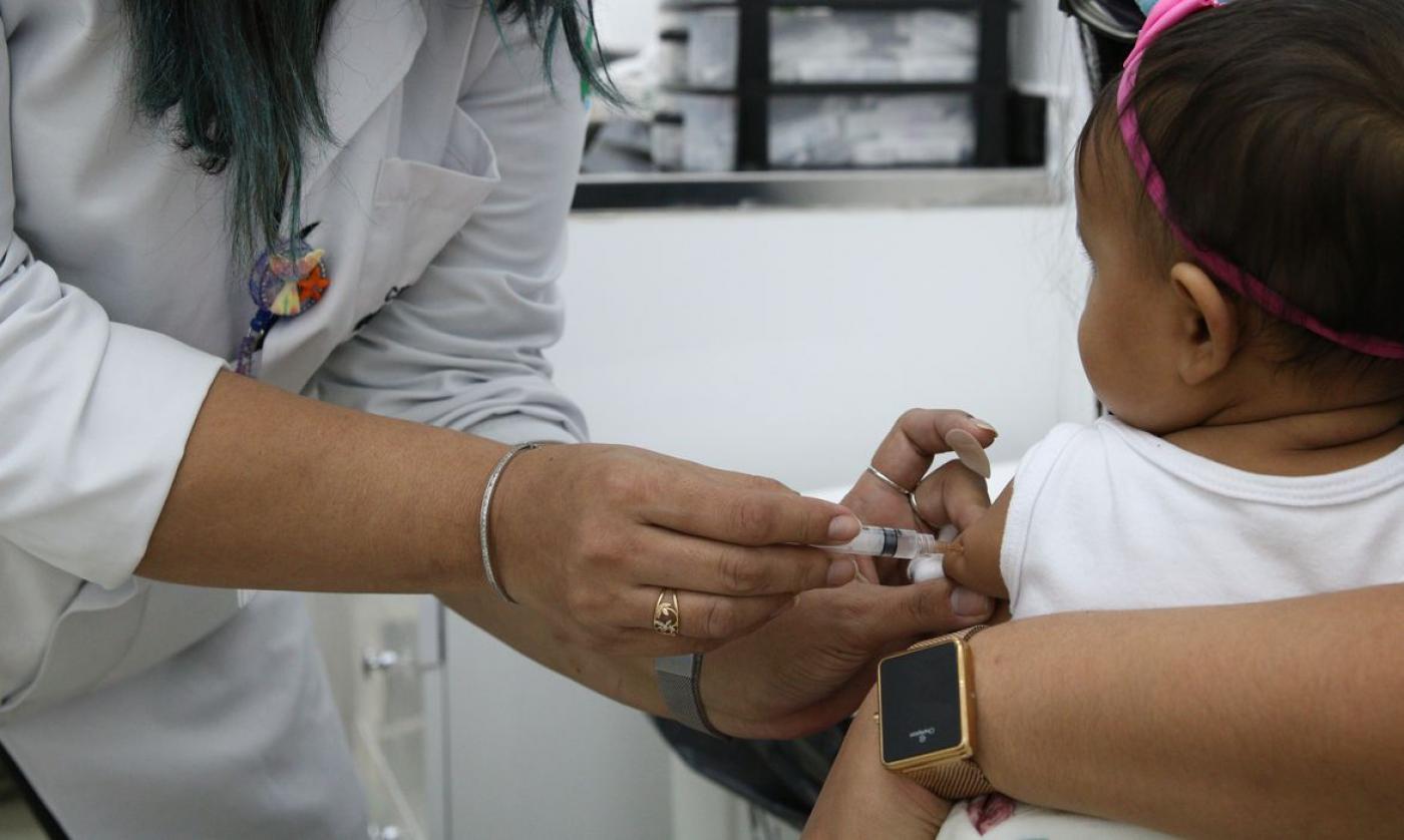 mãos de mulhere vacinam bebê de colo #paratodosverem