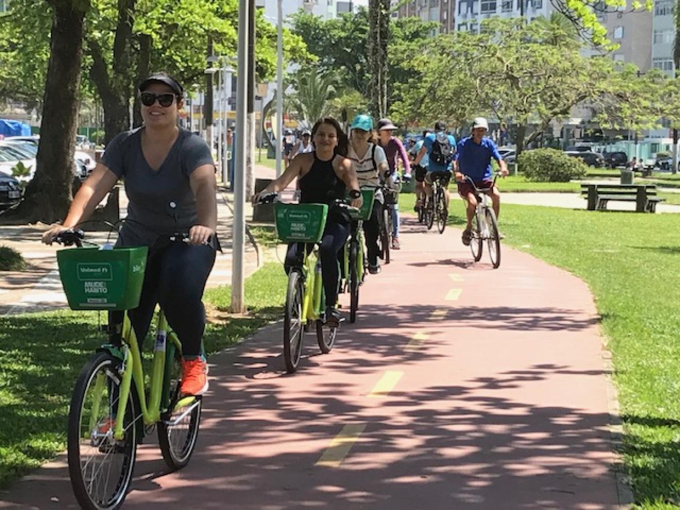 pessoas andando de bicicleta pela ciclovia da orla #pracegover 