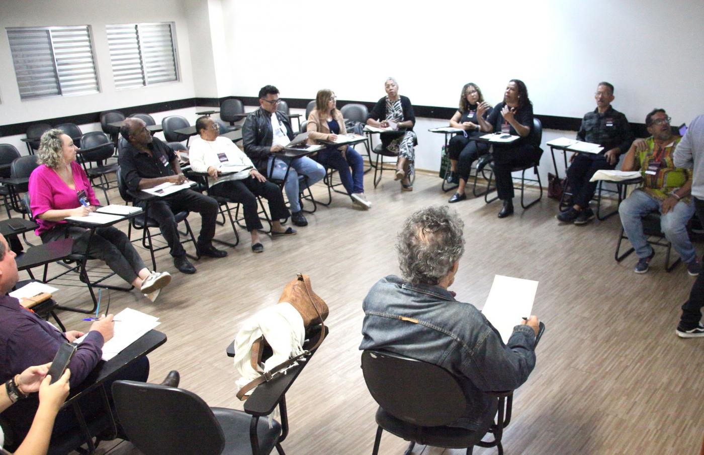 pessoas reunidas em sala estão discutindo. #paratodosverem