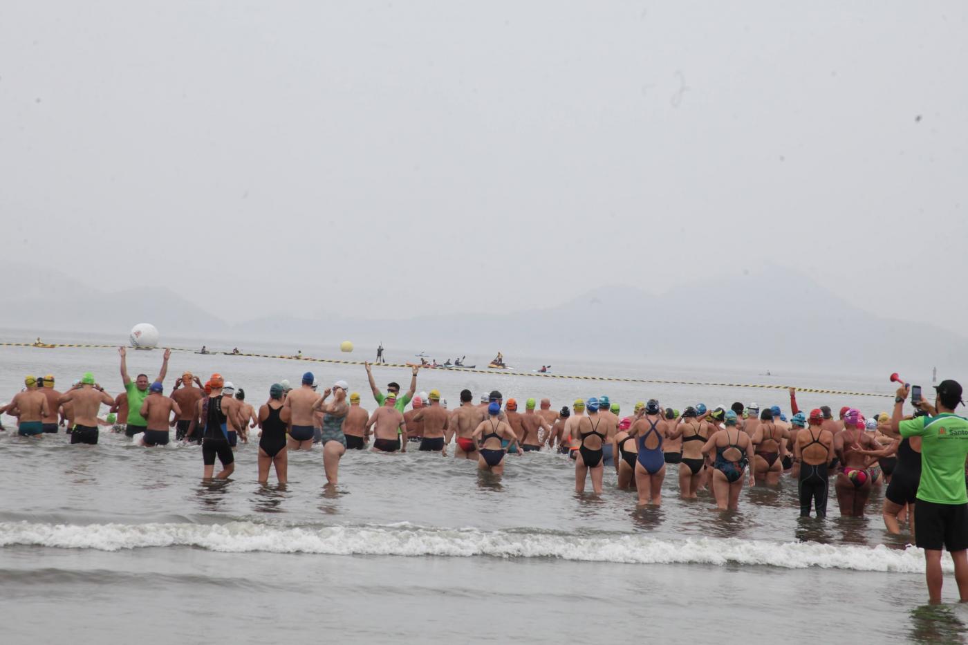 nadadores estão na beira do mar para iniciar prova. #paratodosverem 