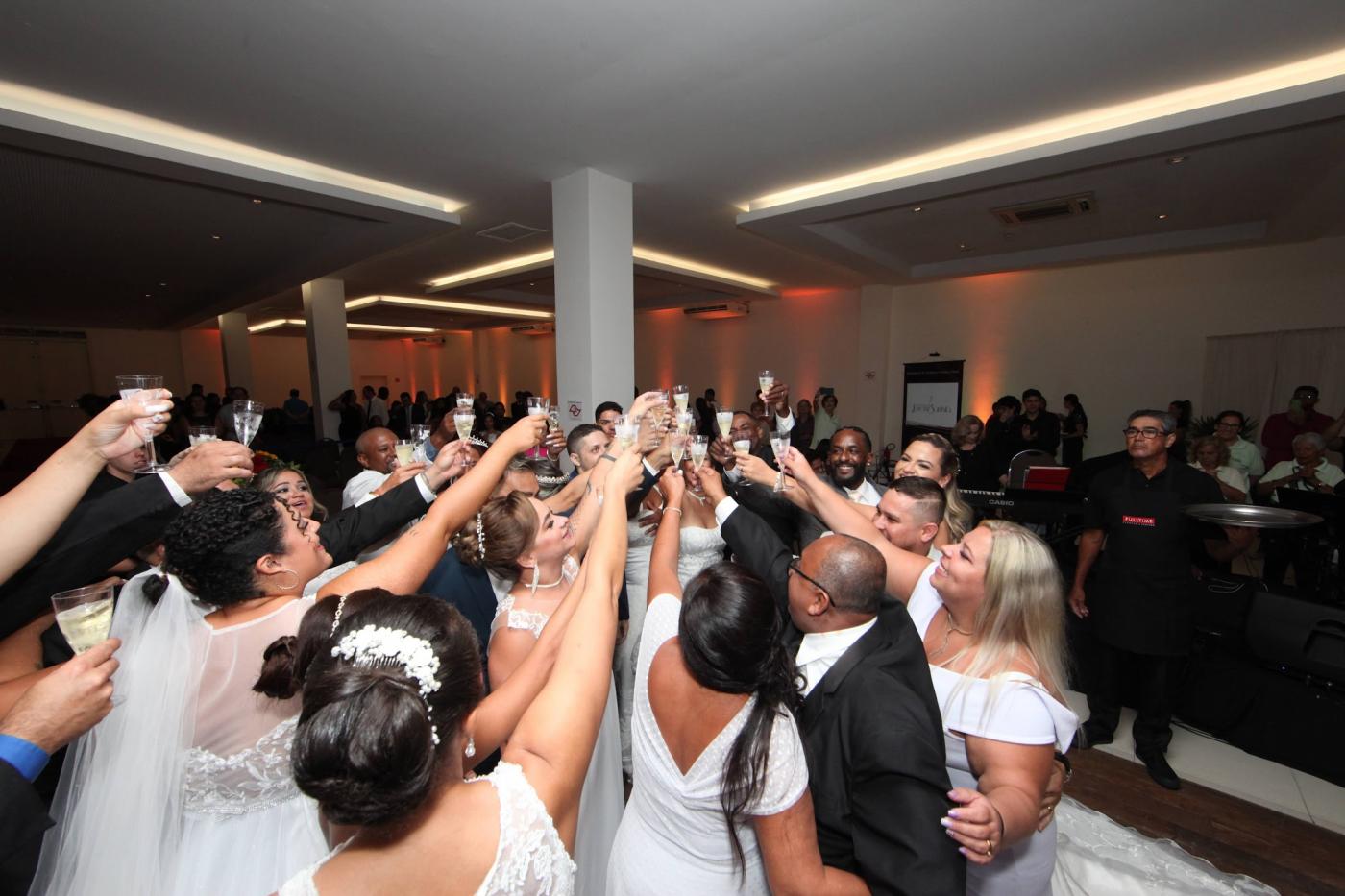 casais de noivos brindam juntos com copos nas mãos. #paratodosverem