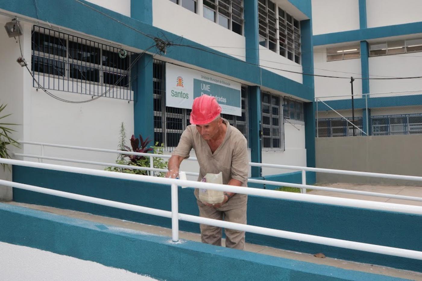 homem pinta corrimão de rampa de acesso. #paratodosverem
