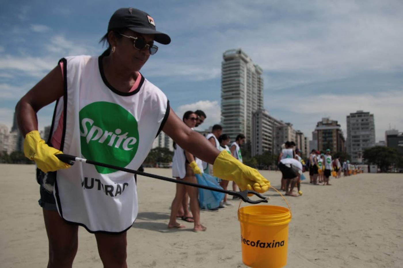 mulher recolhe lixo da praia #paratodosverem 