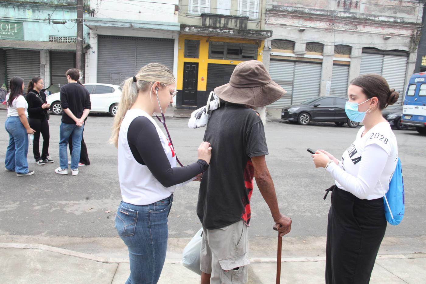 voluntária ausculta pulmão de paciente em situação de rua #paratodosverem