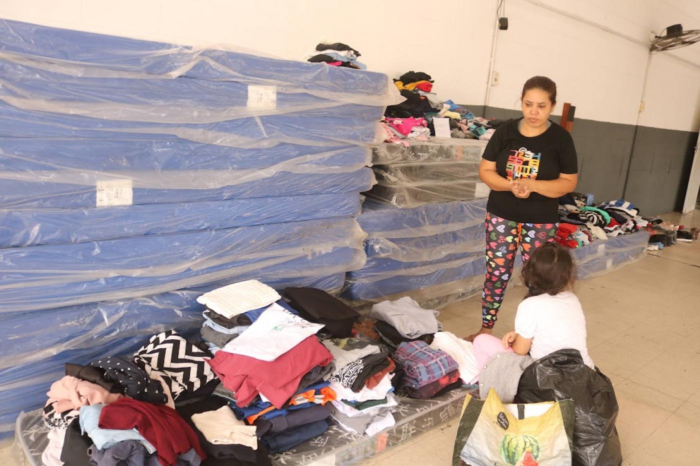 pessoas pegam doações em abrigo #paratodosverem