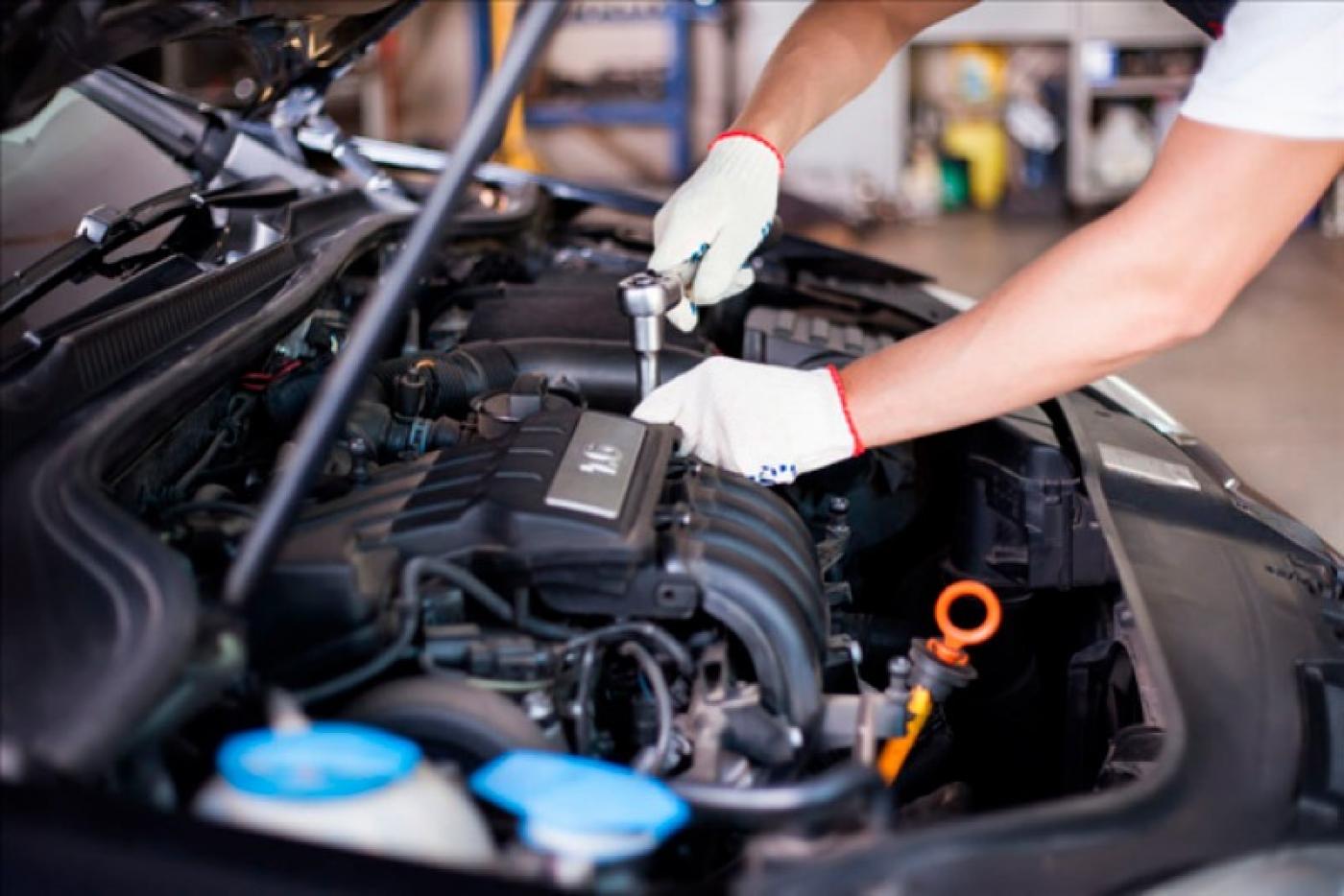 imagem em close de mãos ajustando motor de veículo. #paratodosverem