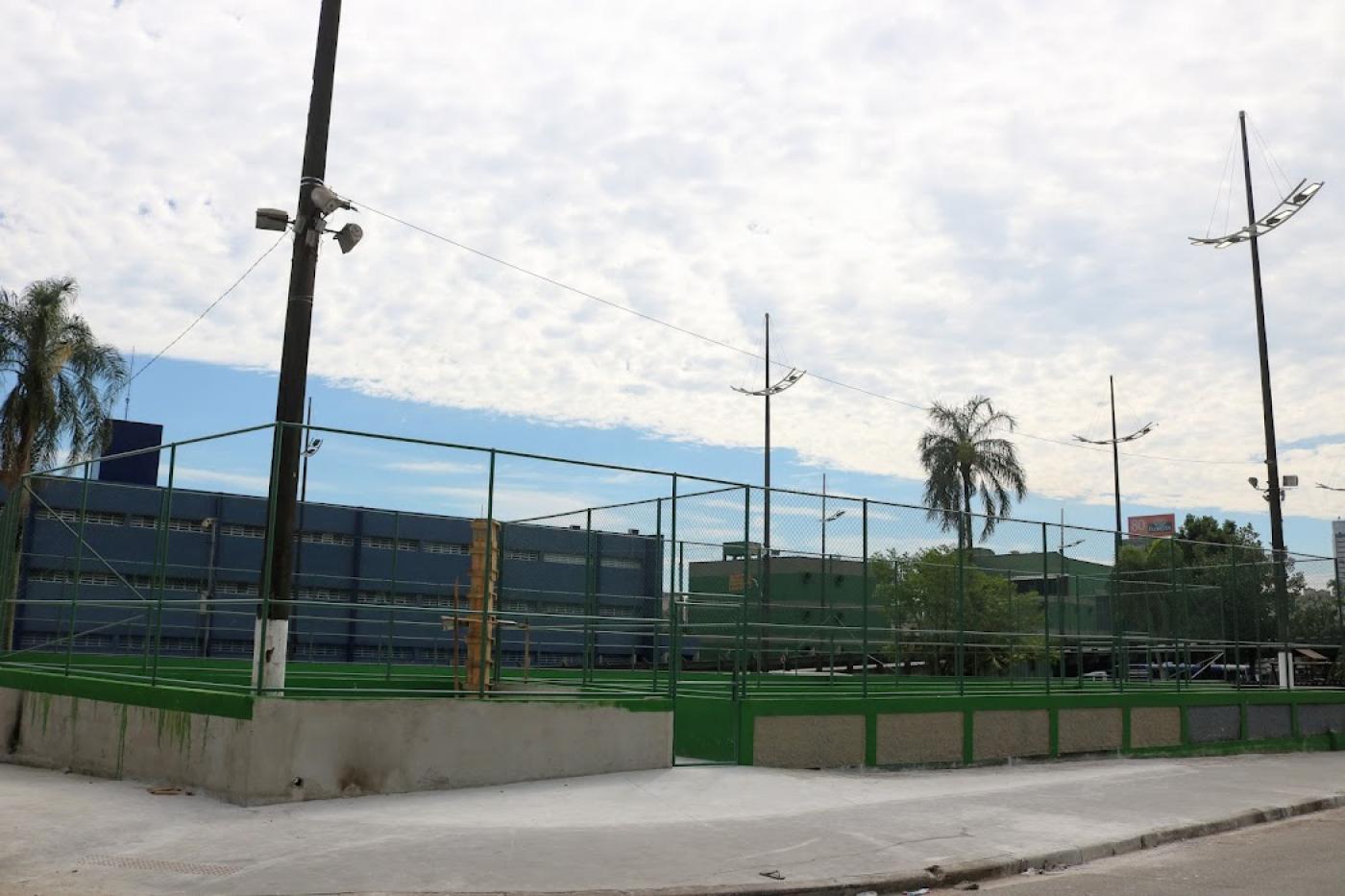 Foto externa da quadra cercada por grades em praça #paratodosverem