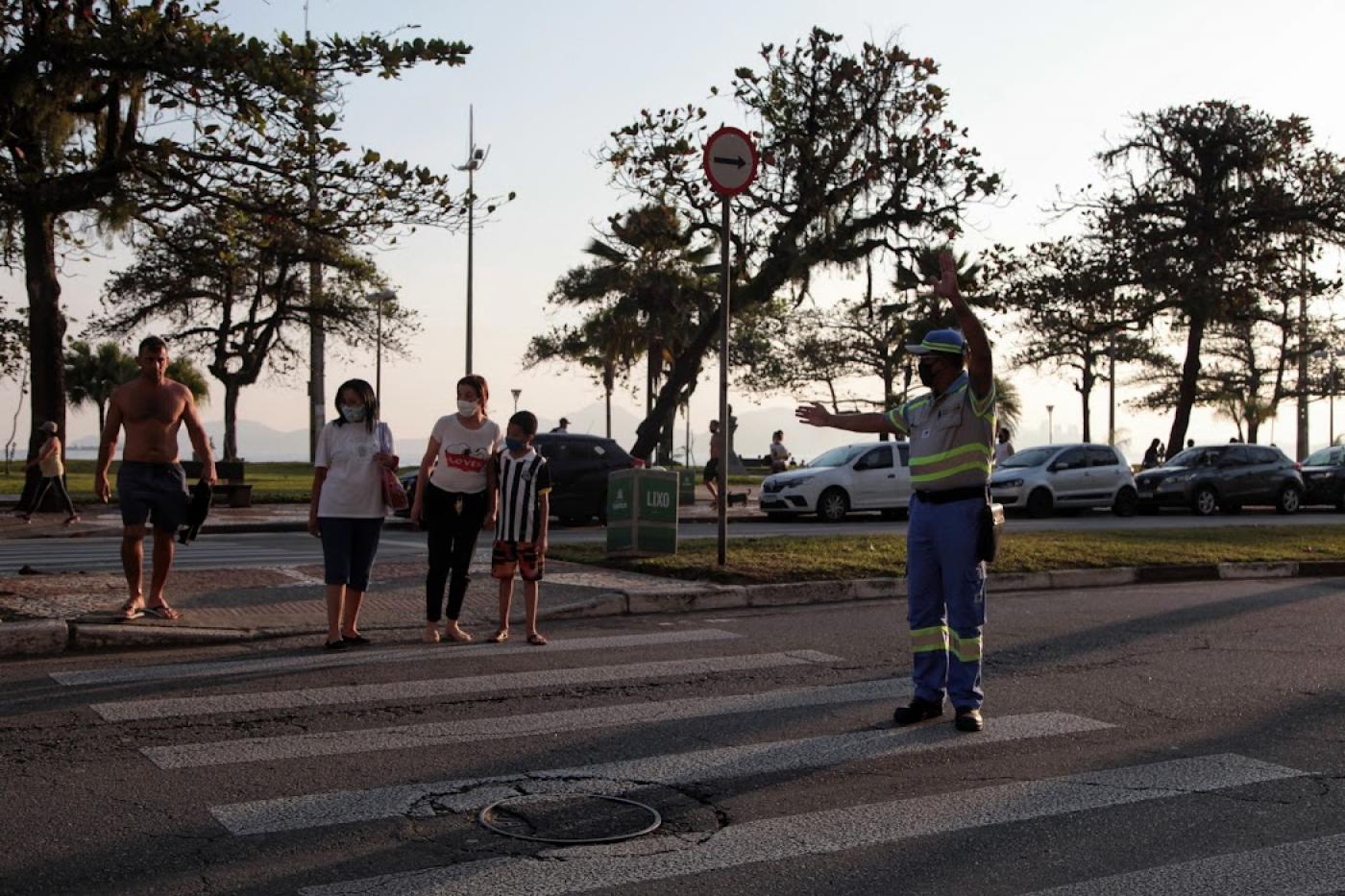 agente faz sinal na avenida e pedestres começam a atravessar na faixa #paratodosverem