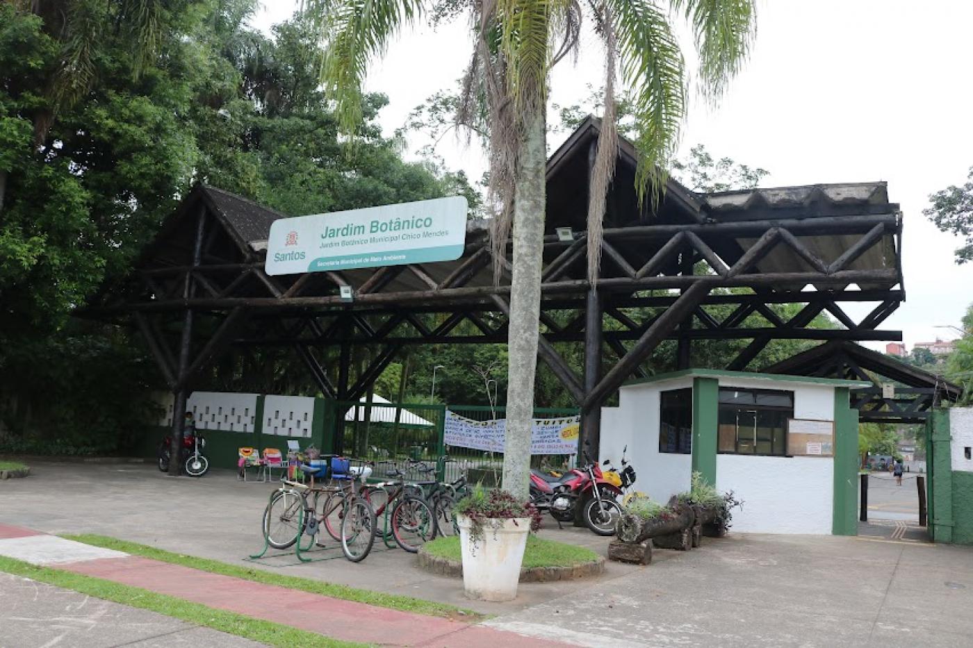 fachada do jardim botânico, com palmeira na entrada e bicicletas estacionadas. #paratodosverem