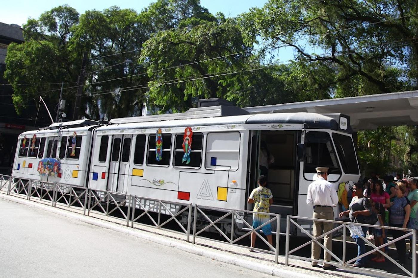 Pessoas subindo no bonde turístico. #paratodosverem