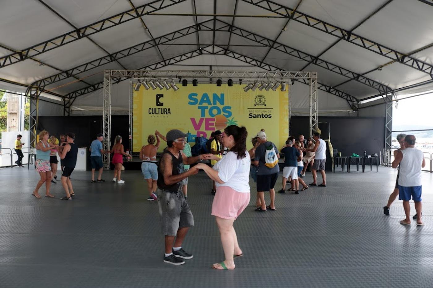 casais dançam sob tenda.#paratodosverem 