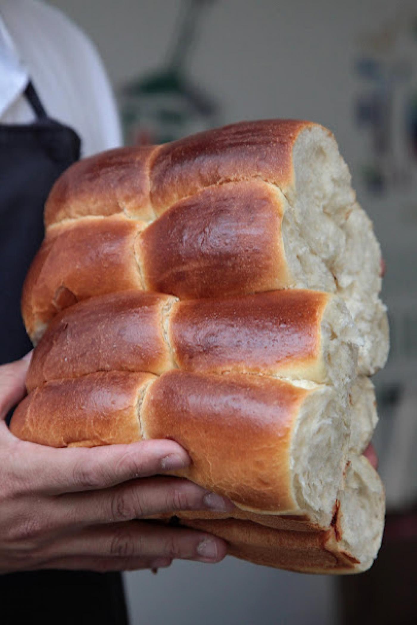 mãos seguram oito pães de cará. #paratodosverem