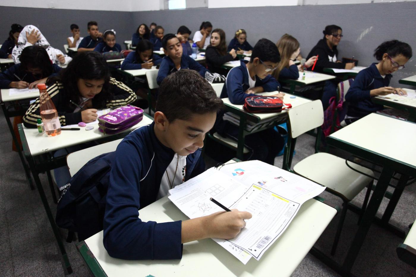 Crianças em sala de aula lendo #pracegover 