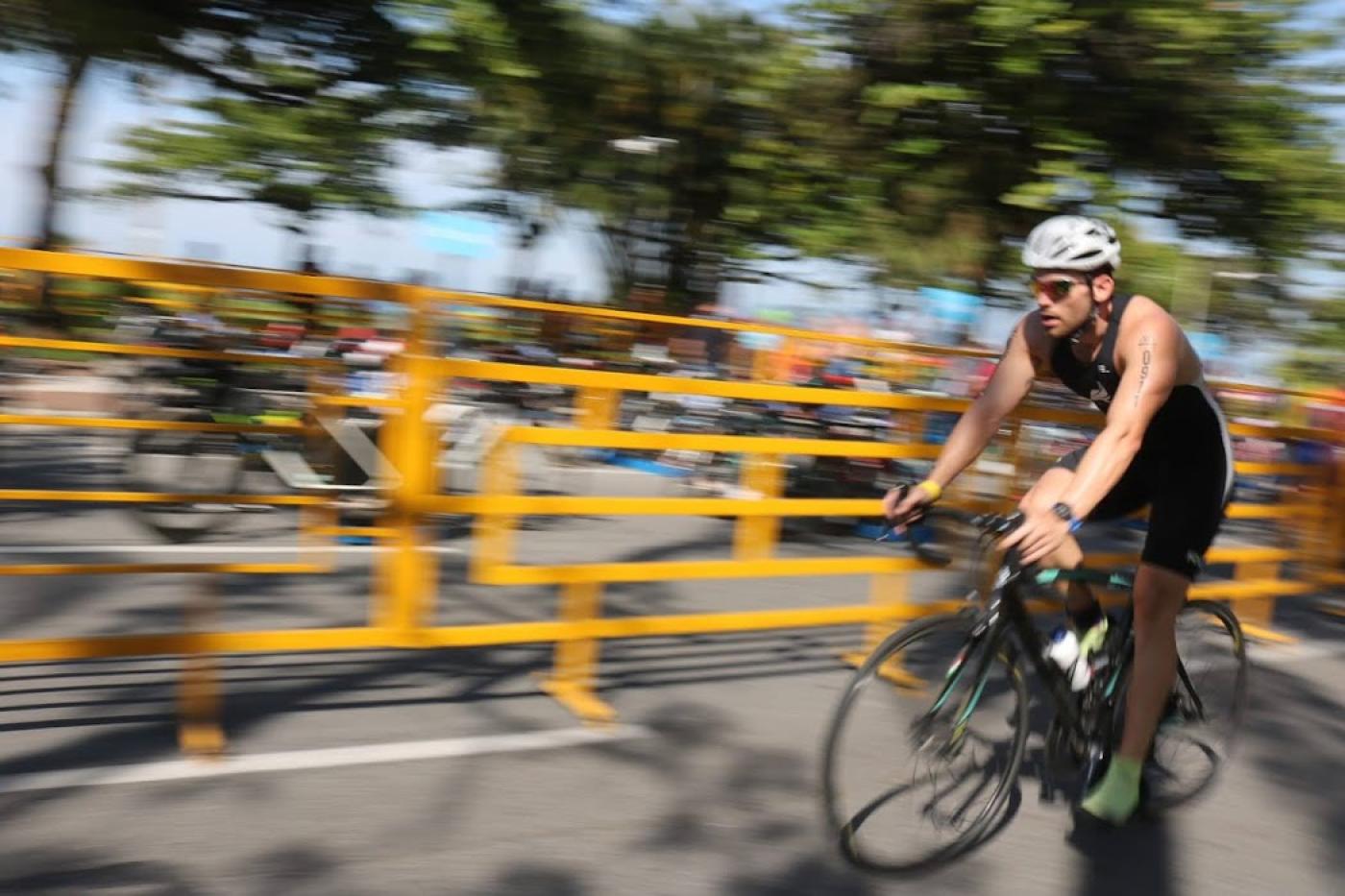 ciclista em prova de triátlon em avenida #paratodosverem
