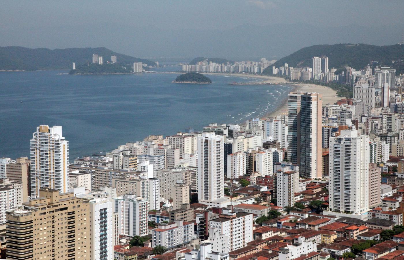 Vista geral da Cidade, desde a massa de concreto, formada por casas e prédios, até a orla. #Paratodosverem