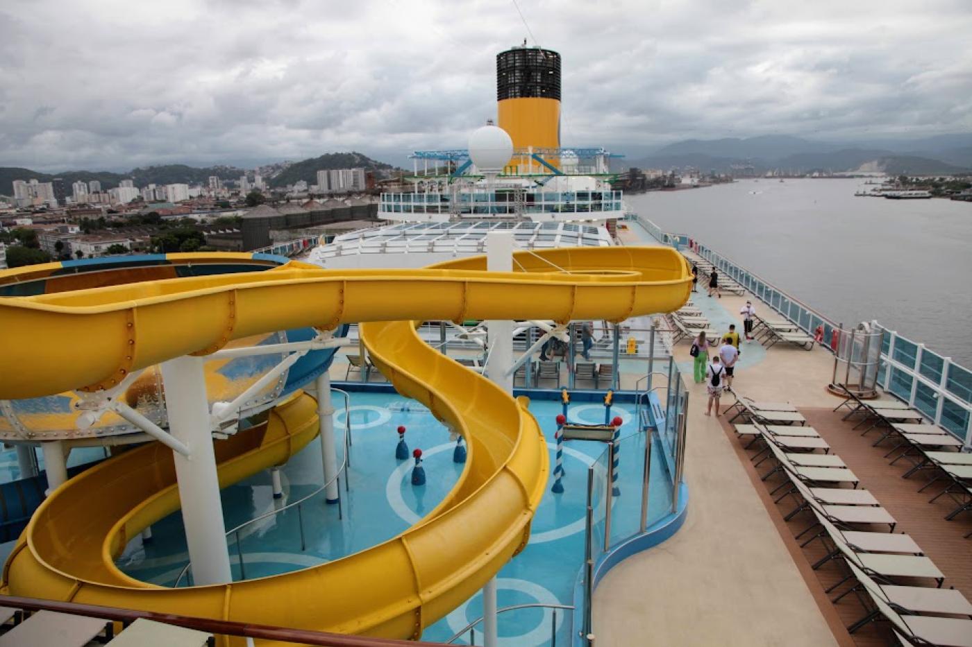 vista geral do navio com tobogã para piscina em primeiro plano. #paratodosverem