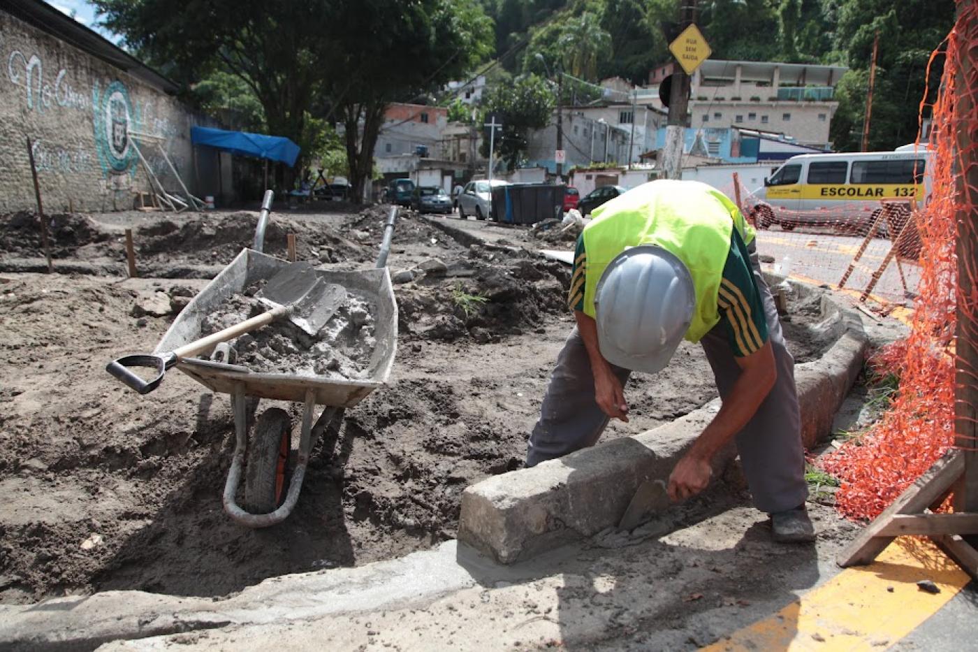 homem está construindo guia de calçada. #paratodosverem