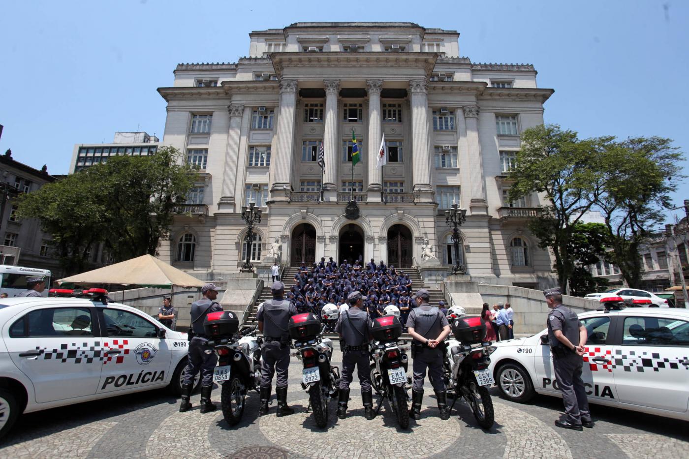 policiais posam na frente do paço com viaturas #pracegover 