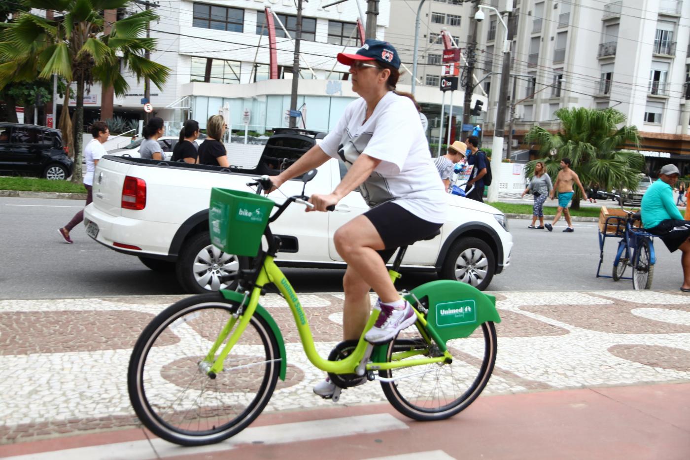 mulher passa com bicicleta pela ciclovia #pracegover 