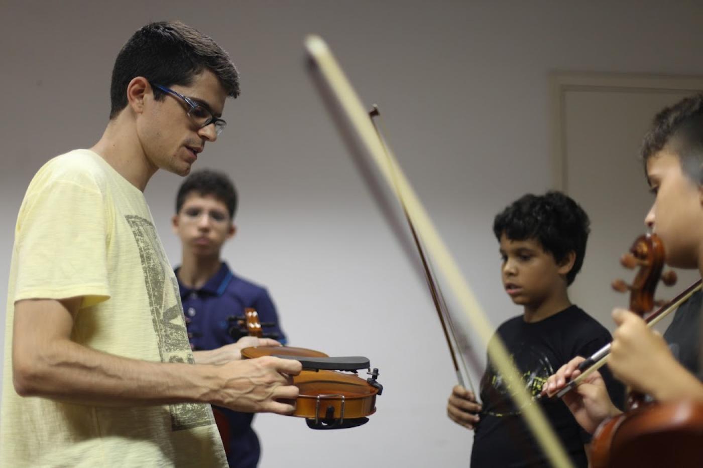 professor instrui alunos sobre instrumentos #paratodosverem