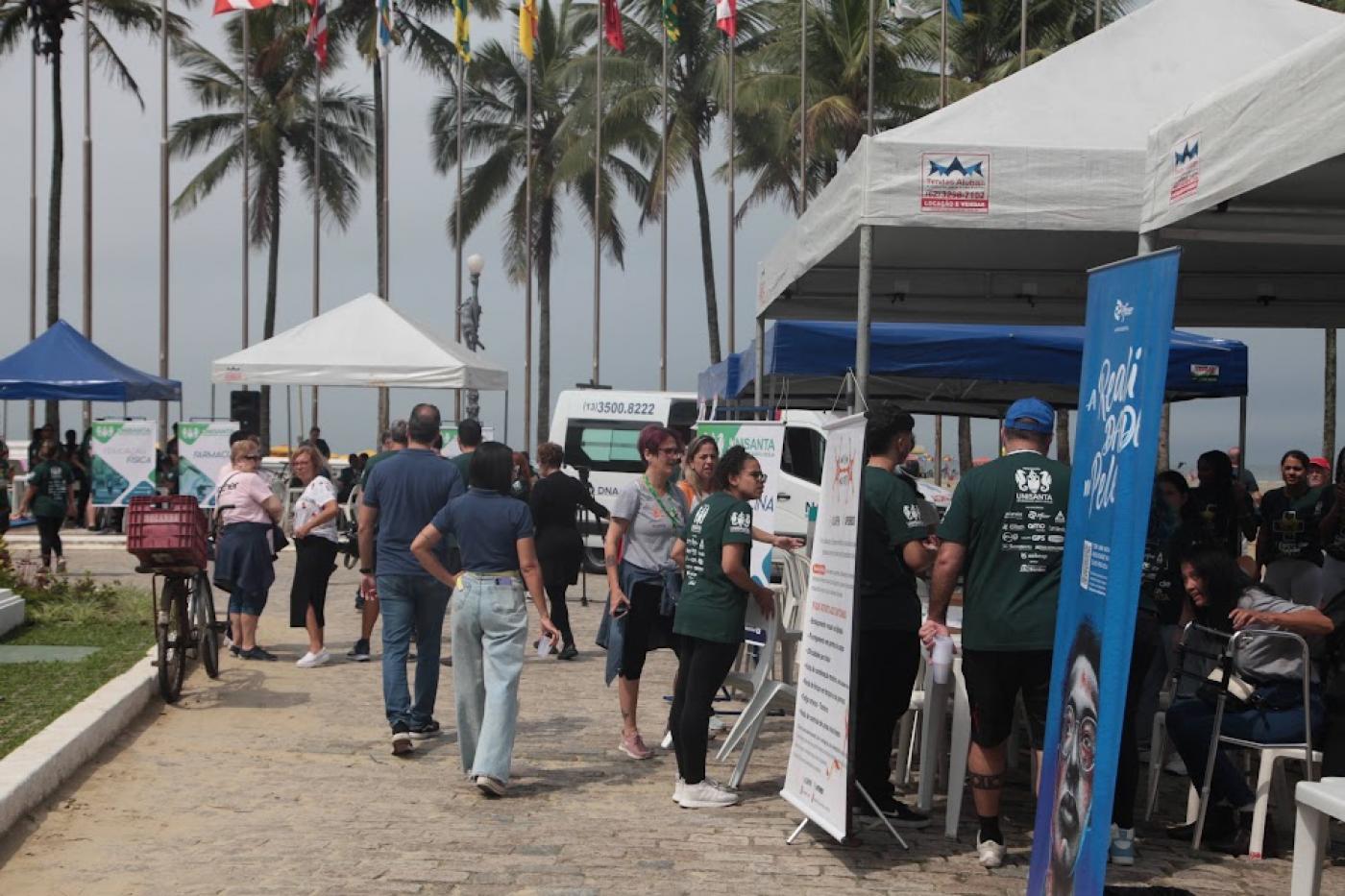 tendas em praça com pessoas em torno. #paratodosverem