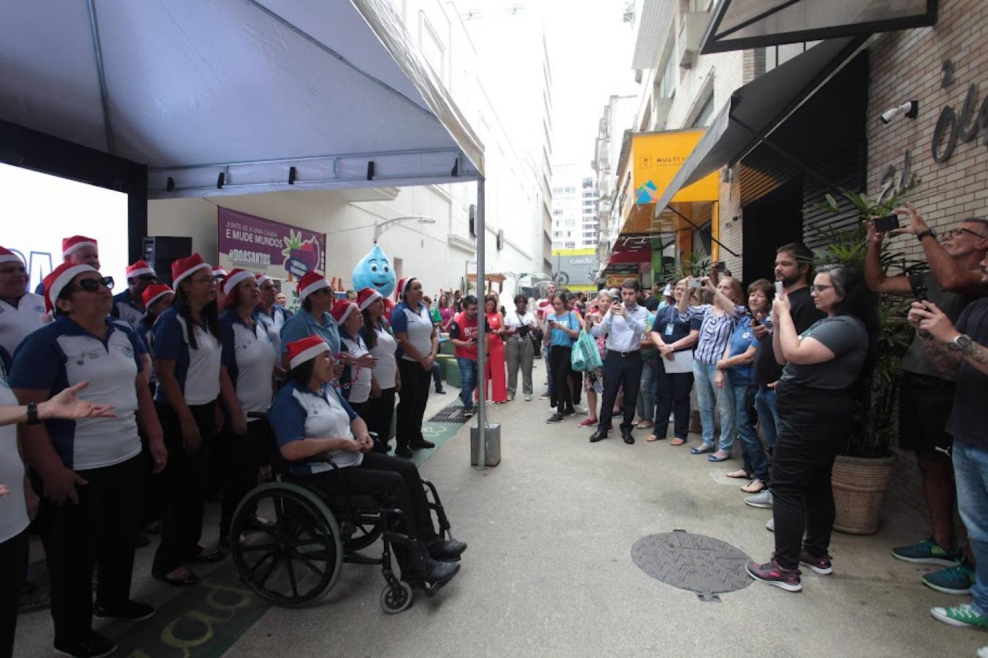 coral se apresenta sob toldo e público assiste. #paratodosverem 