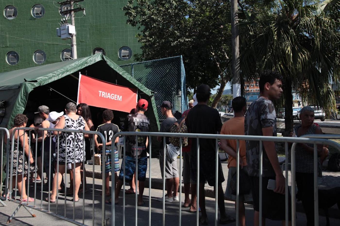 pessoas formam fila diante de tenda para receber atendimento. #paratodosverem 