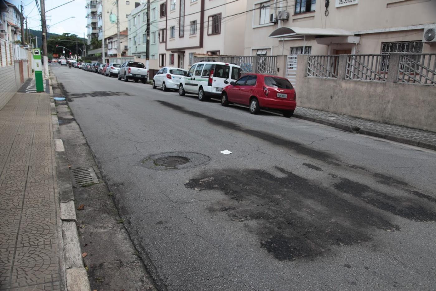 Rua com carros parados do lado direito. #Paratodosverem