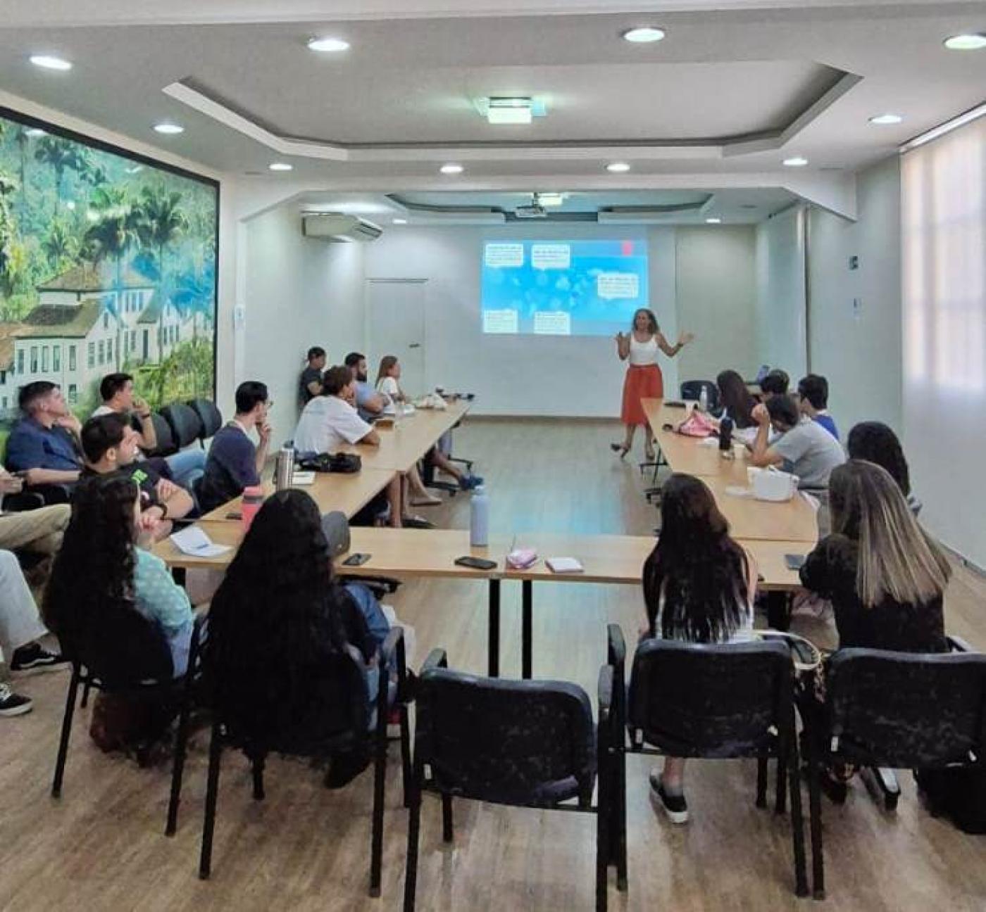 jovens reunidos em sala sentados em mesa #paratodosverem 