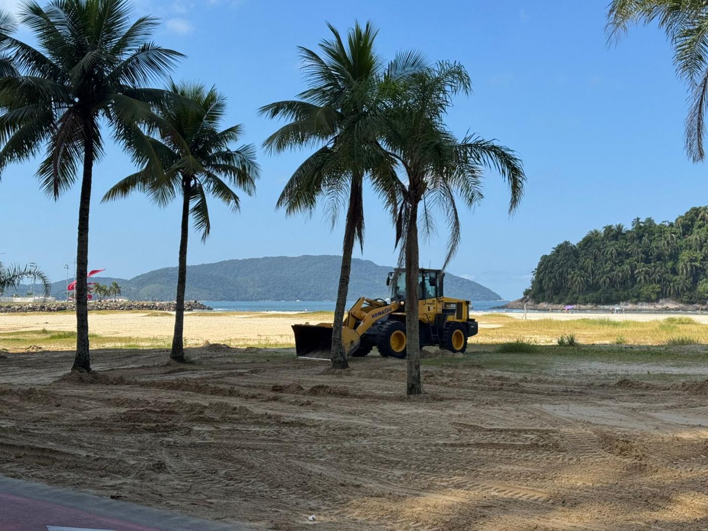 máquina atuando na praia #paratodosverem 