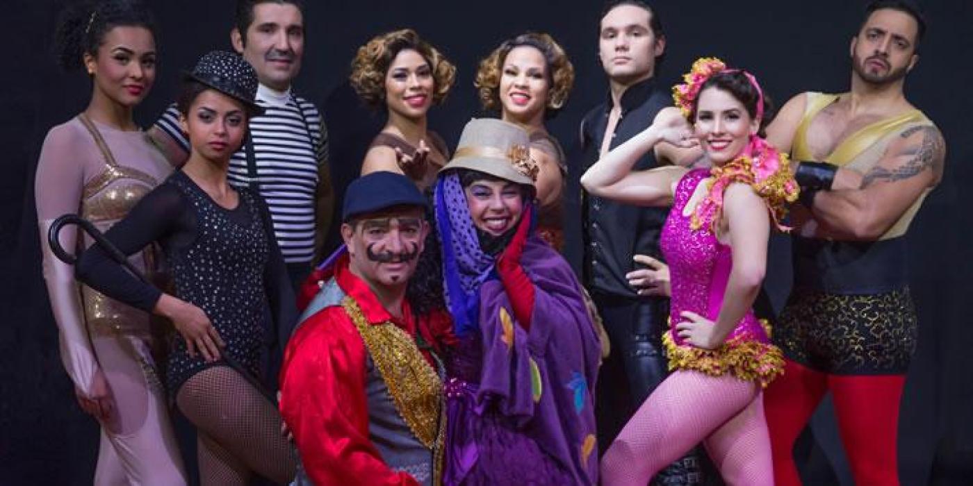 Artistas fantasiados com roupas de circo posam para foto. #paratodosverem