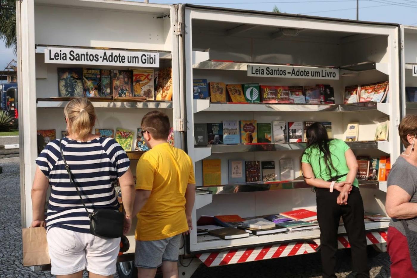 Biblioteca móvel aberta com pessoas olhando para o interior. #paratodosverem