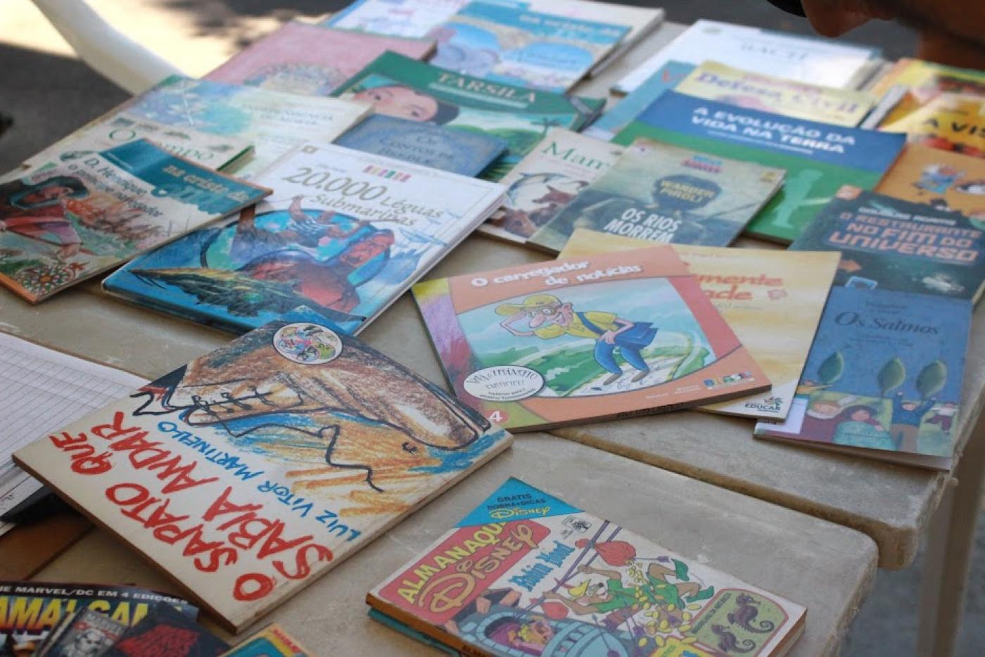 vários livros expostos sobre uma mesa. #paratodosverem