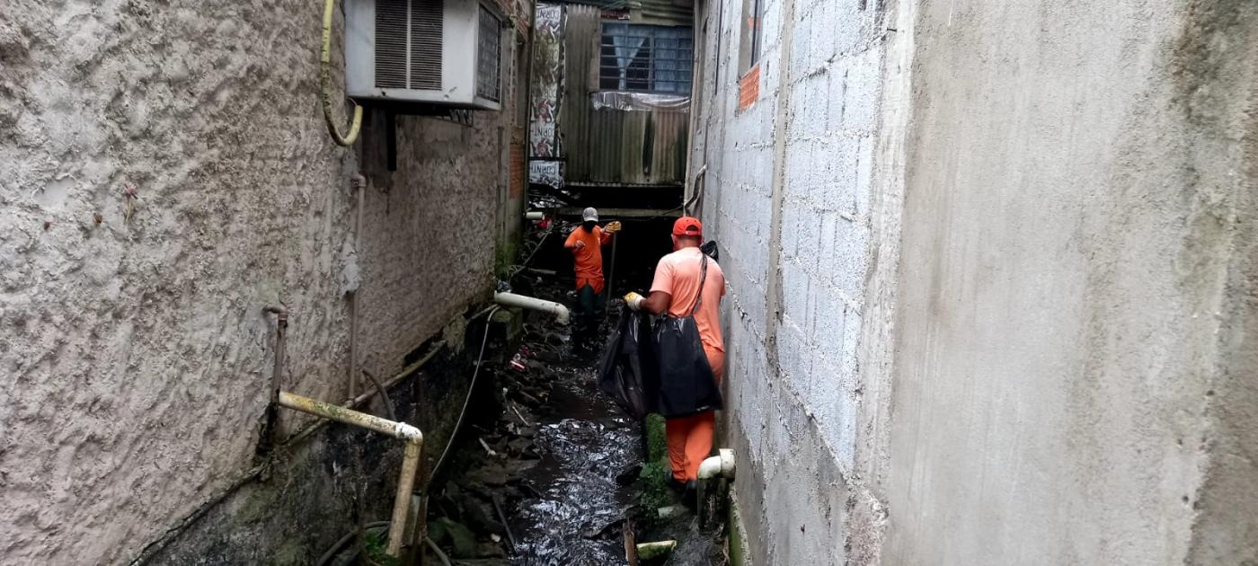 homens estão dentro de córrego fazendo limpeza. #paratodosverem