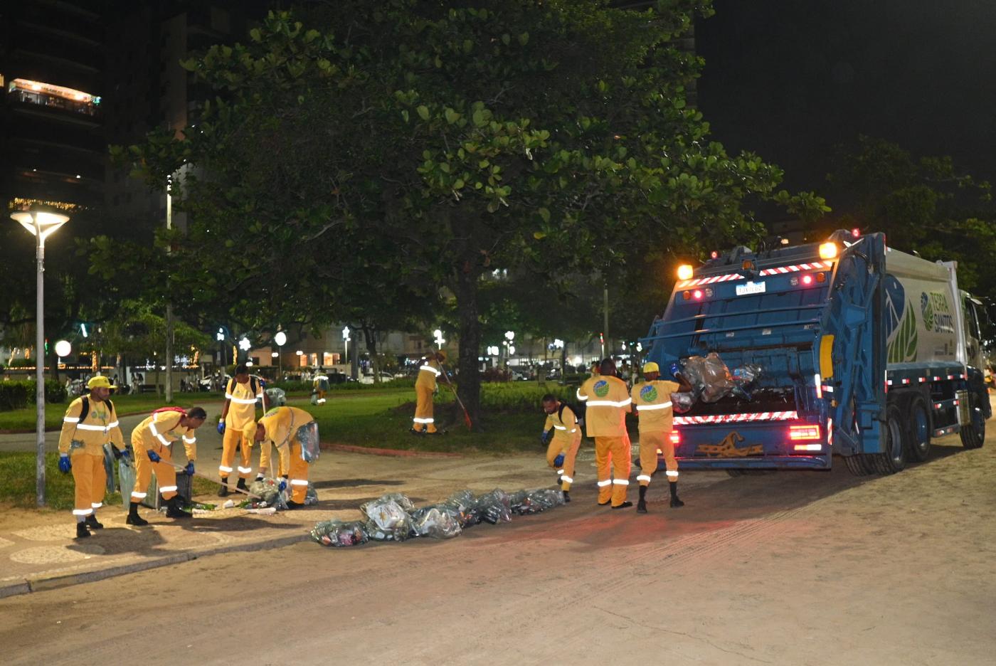funcionários recolhem lixo na faixa de areia e jardim. #paratodosverem