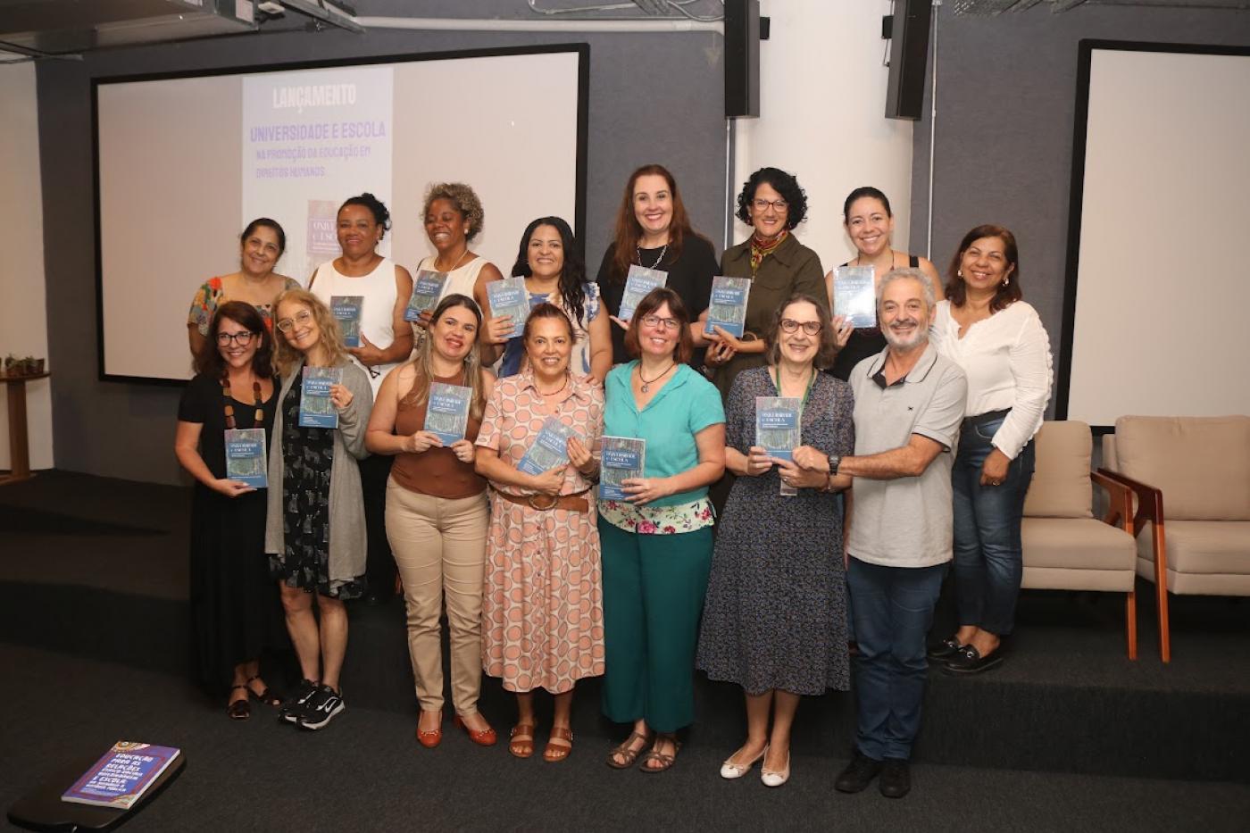 pessoas segurando os livros #paratodosverem