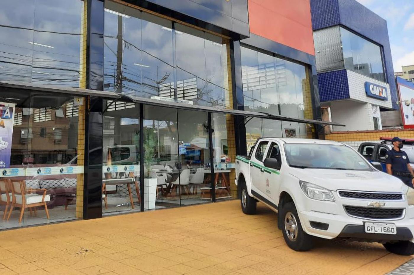 Viatura da Prefeitura está parada na área de estacionamento de loja aberta. #Paratodosverem