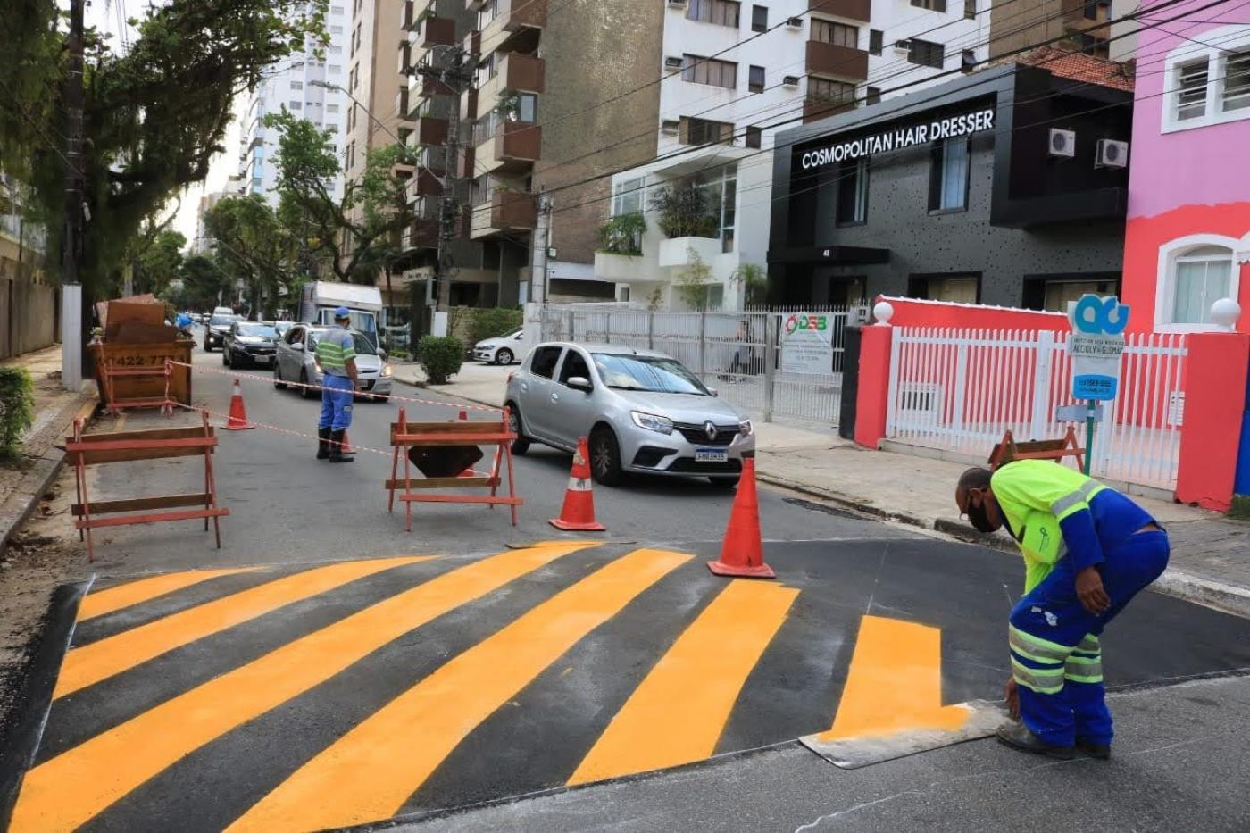 Operário faz pintura de lombada ao lado esquerdo da via. #paratodosverem