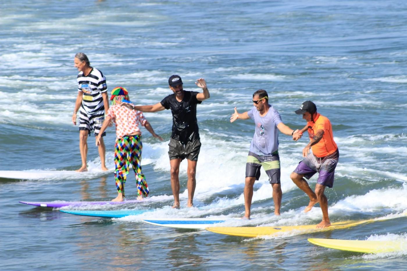 pessoas surfando em longboards #paratodosverem