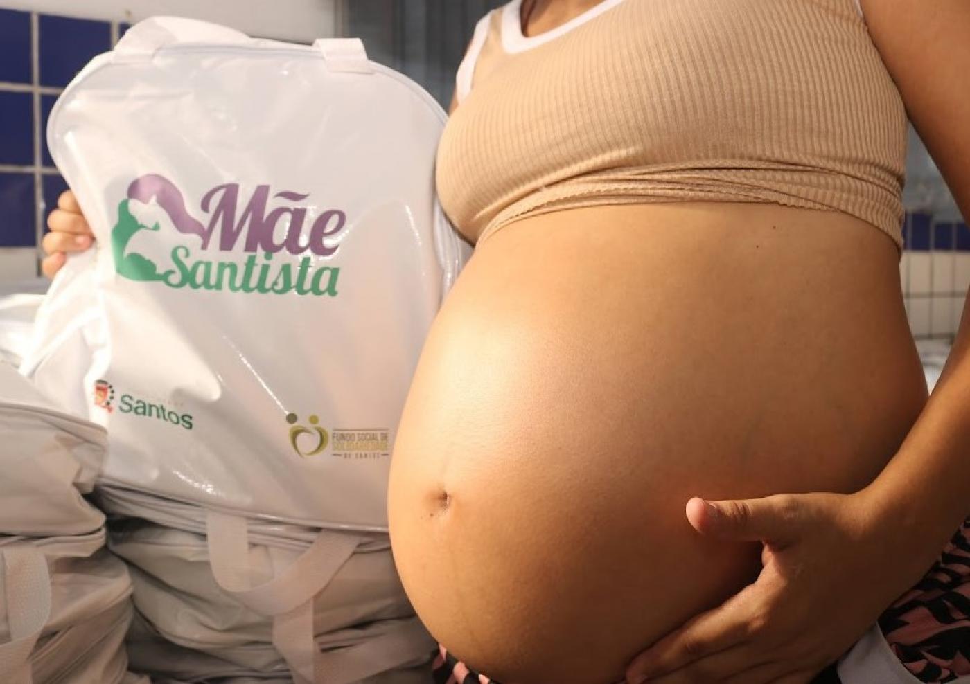 mulher grávida segura bolsa do mãe santista #paratodosverem 