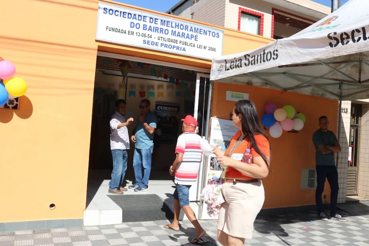 Pessoas passam em frente a sede da sociedade de melhoramentos.