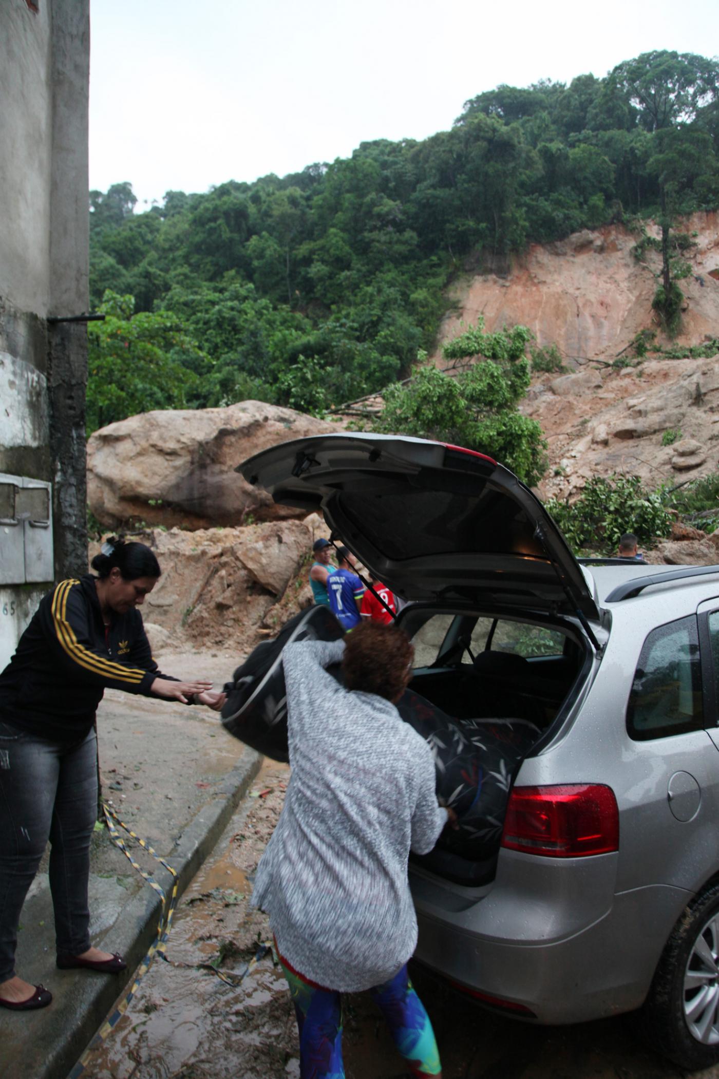 pessoas colocam pertences em carro #paratodosverem 