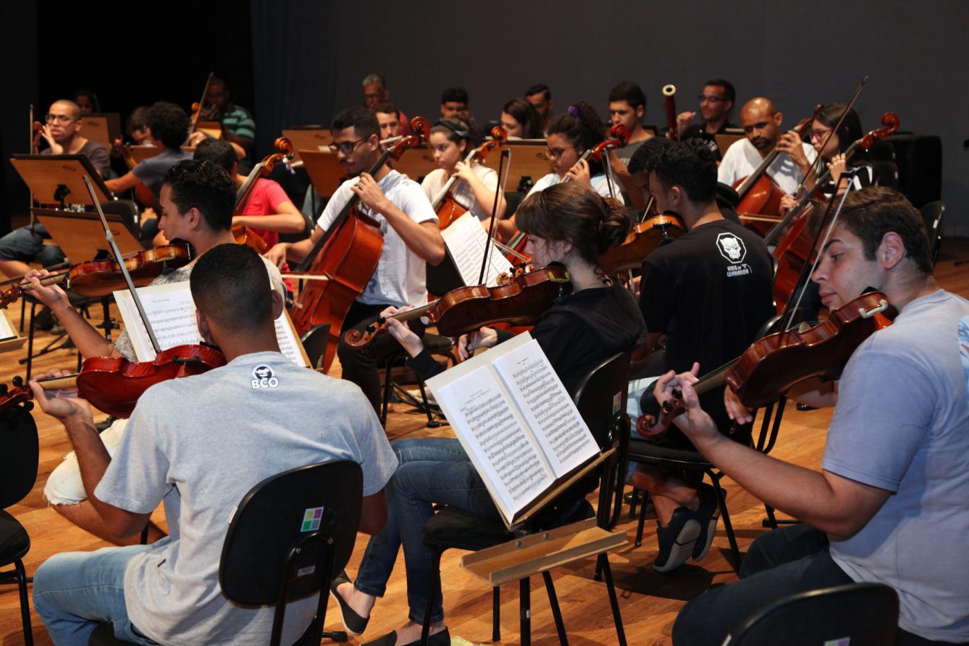 jovens tocam instrumentos em orquestra #pracegover