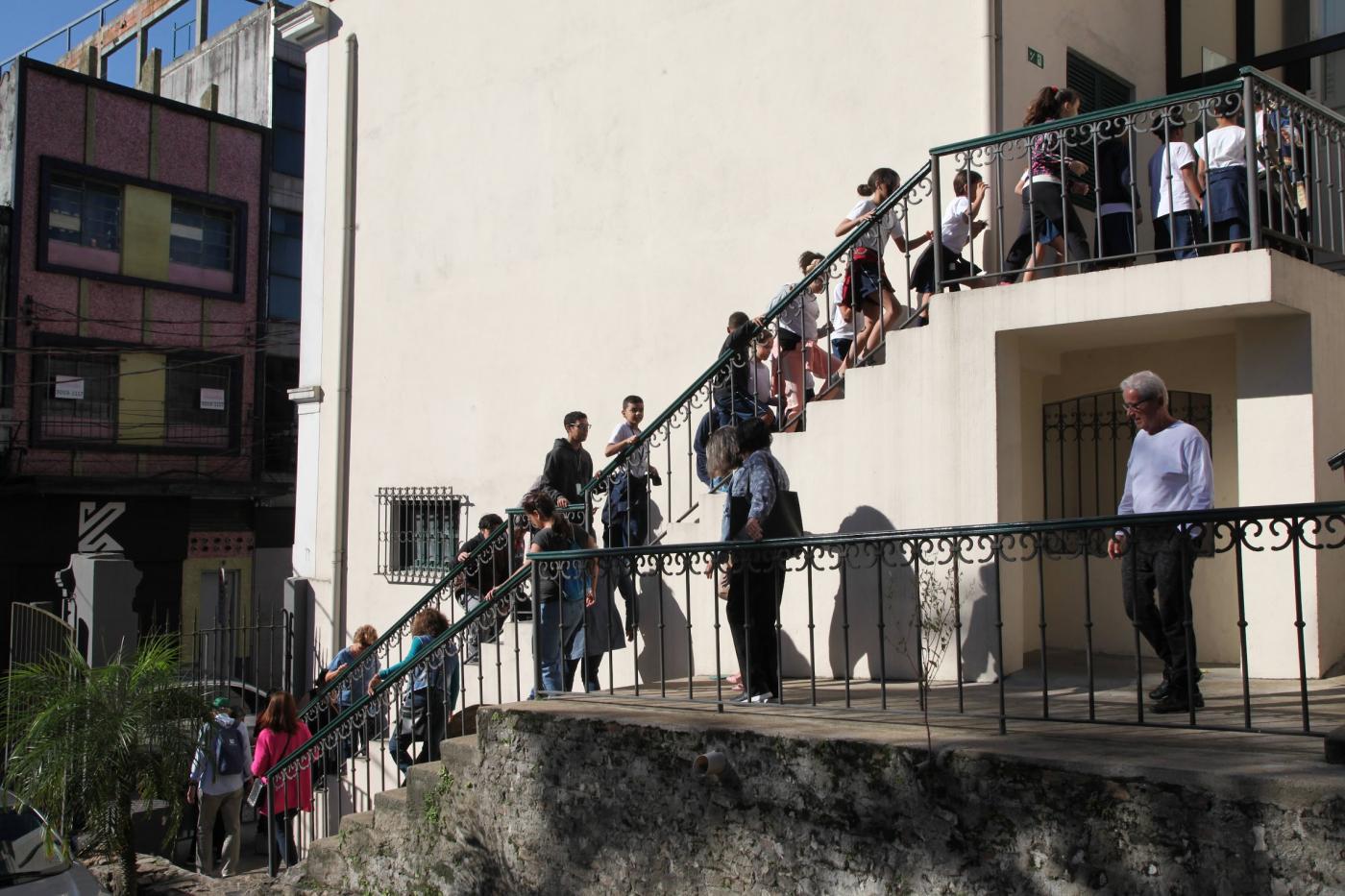 público sobe escada externa do outeiro de santa catarina. #paratodosverem