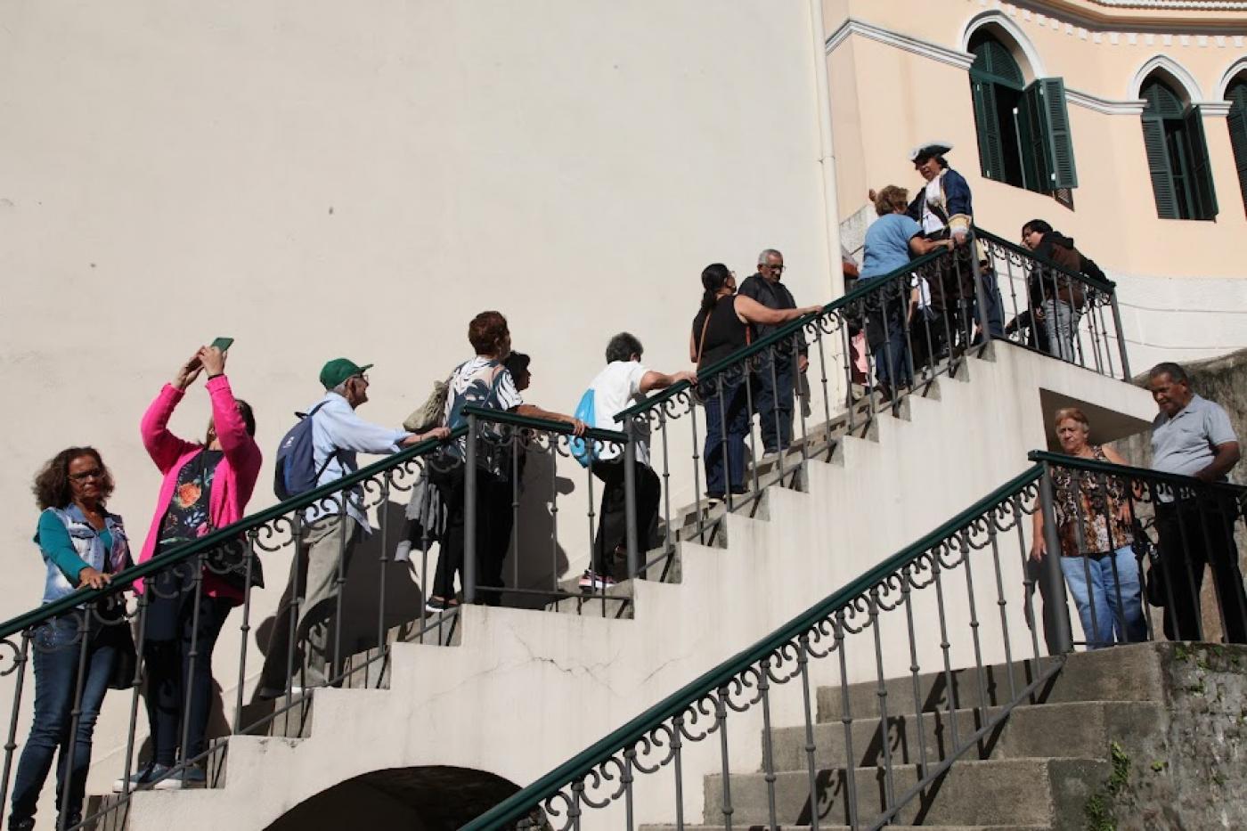 visitantes sobem escadaria externa de acesso ao outeiro de Santa Catarina. #paratodosverem 