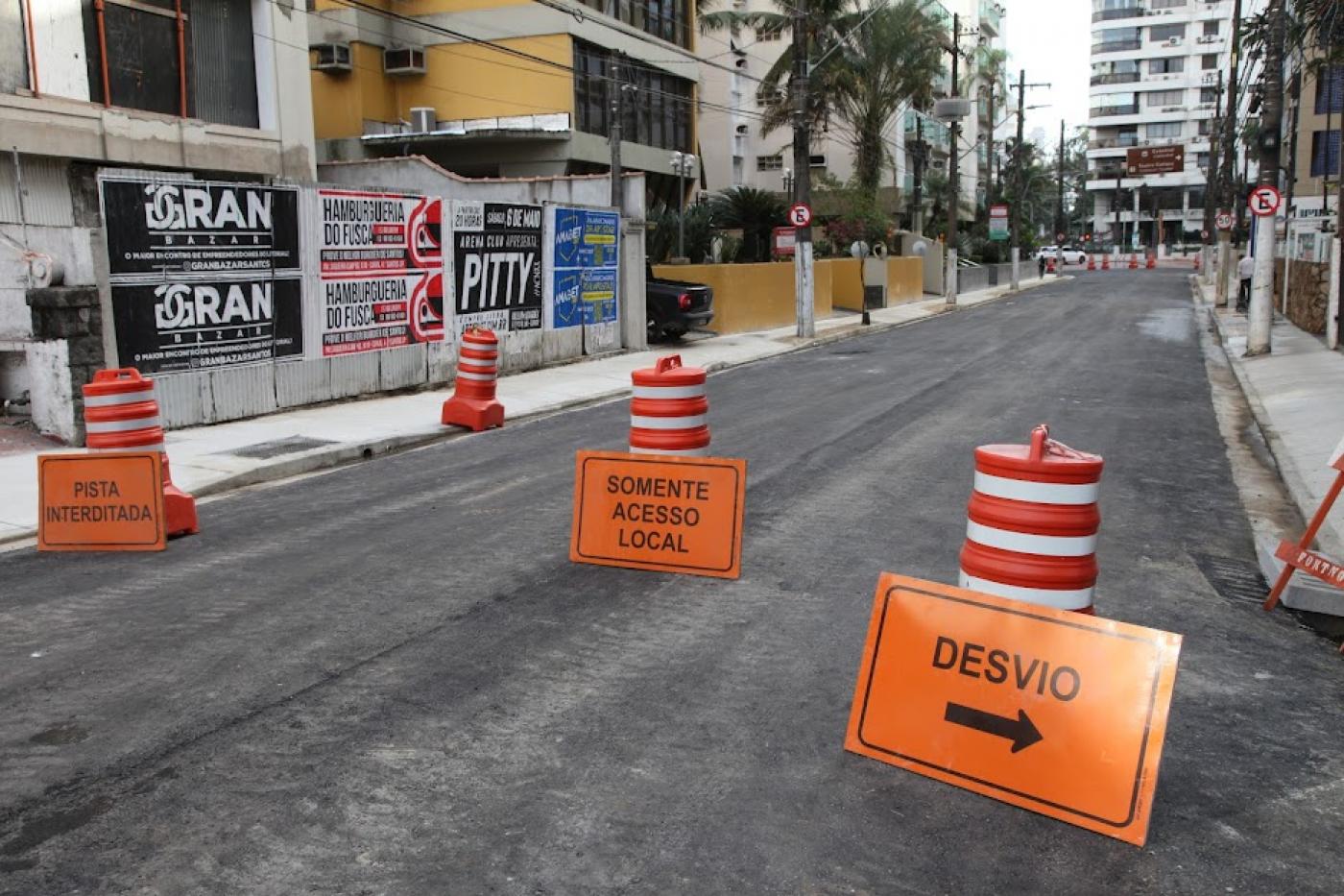 rua está recém-asfaltada. cones em primeiro plano informam sobre acesso local. #paratodosverem 