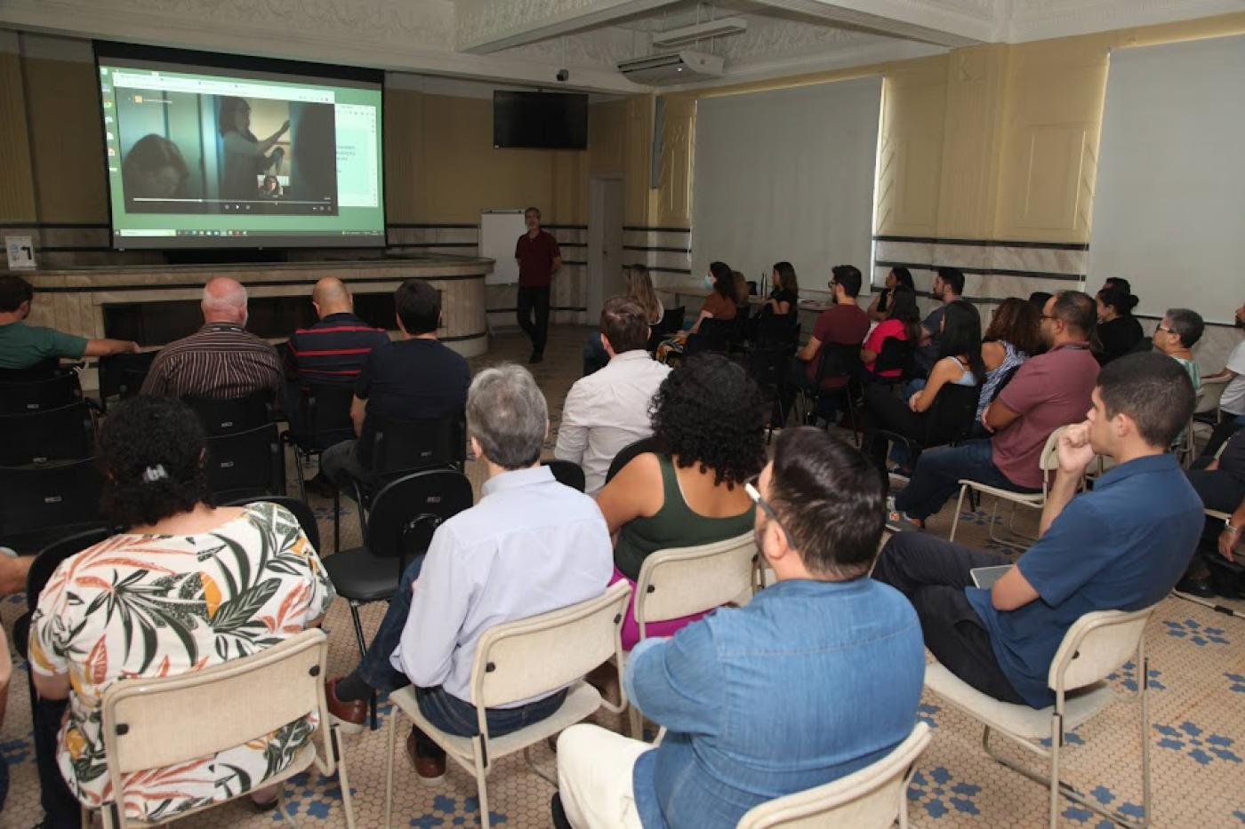 servidores assistem a vídeo na palestra #paratodosverem