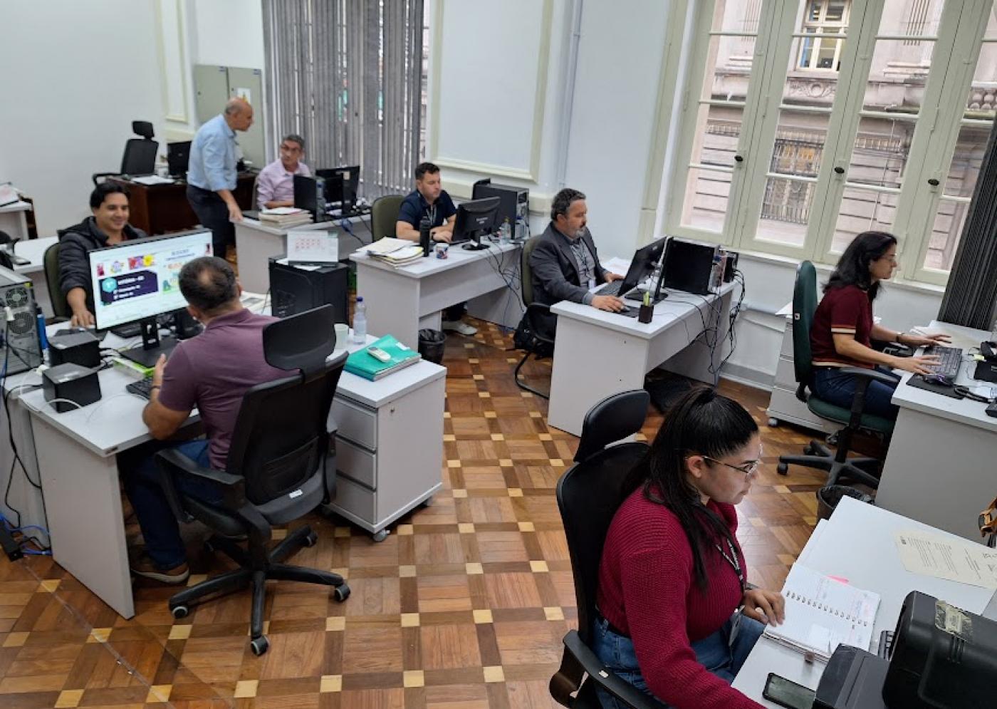 pessoas sentadas trabalhando em uma sala #paratodosverem
